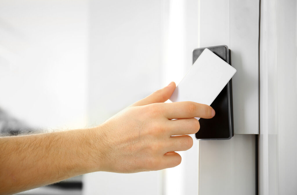 Security alarm keypad with male hand and card, closeup